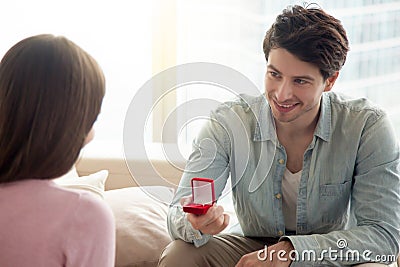Young man holding engagement ring, making marriage proposal to g Stock Photo