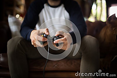 A young man holding joystick, playing video game. Stock Photo