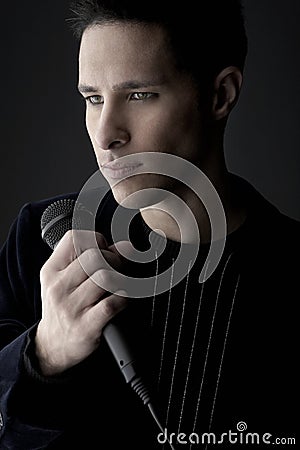 Young man holding microphone close-up Stock Photo