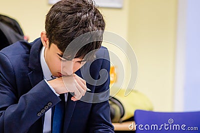 A Young Man Holding a Pen Concentrating Stock Photo
