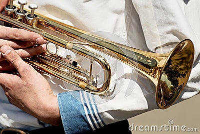 A young man holds a trumpet musical instrument. Stock Photo