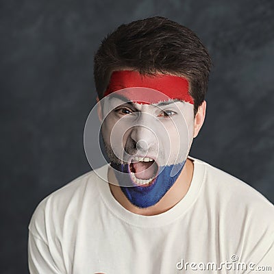 Young man with Holland flag painted on his face Stock Photo