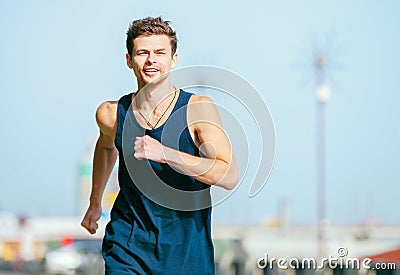 Young man jogging at the street in summer morning time Stock Photo