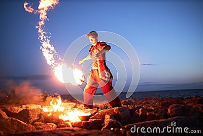 Young man juggling fire poi Stock Photo