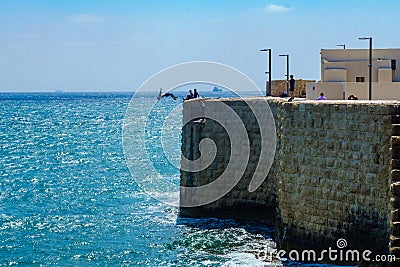 Young man jump from the wall, in Acre Editorial Stock Photo