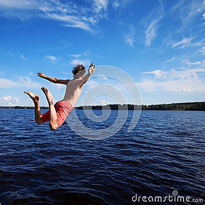 Young man jumping into water Stock Photo