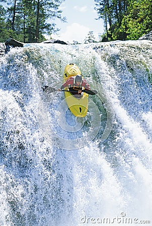 Young man kayaking down waterfall Stock Photo