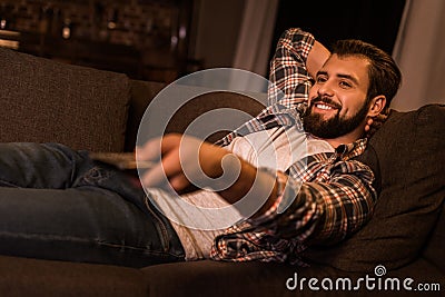 young man laying on couch and watching tv Stock Photo