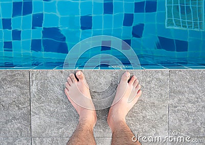 Young man legs standing on border front of swimming pool Stock Photo