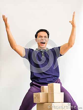 The young man lift his hand with joy in achieving the goal of wholesale products online for customers Stock Photo