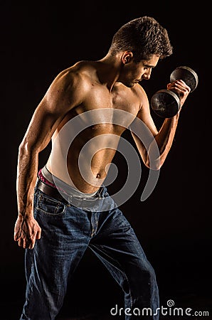 Young Man Lifting Dumbell to Exercise Biceps - Dumbbell Concentration Curl Stock Photo