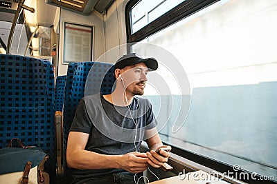 A young man listens to a music or podcast while traveling in a train Stock Photo