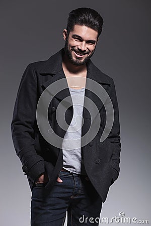 Young man with long beard in an overcoat smiling Stock Photo