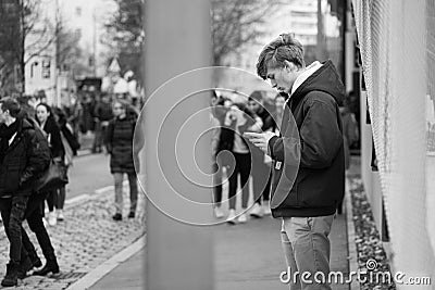 Young man looking at his smartphone during Earth-strike demonstration Editorial Stock Photo