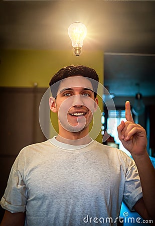 Young man looking at lit up lightbulb. Idea, enlightment concept Stock Photo