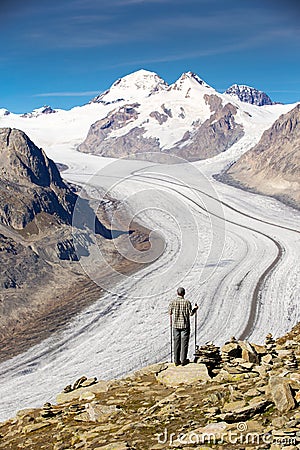 Young man looking at majestic view to Aletsch glacier, the large Stock Photo