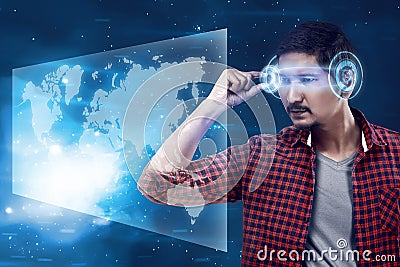 Young man looking world map with futuristic smart high tech glasses Stock Photo