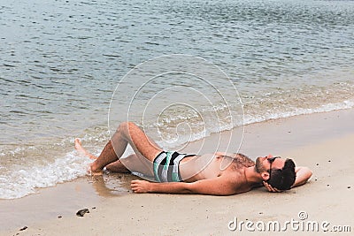 Young man lying on the beach Stock Photo