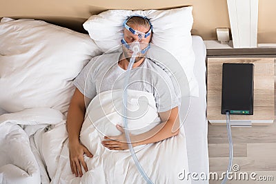 Man With Sleeping Apnea And CPAP Machine Stock Photo