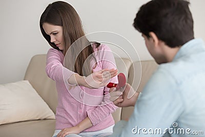 Young man making marriage proposal, engagement ring, lady reject Stock Photo