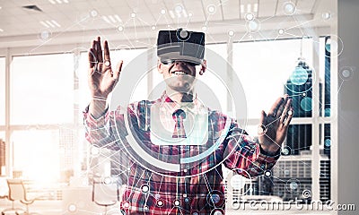 Young man in modern office interior experiencing virtual reality Stock Photo