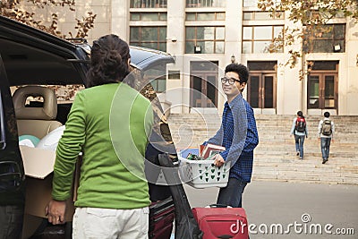 Young man moving into dormitory on college campus Stock Photo