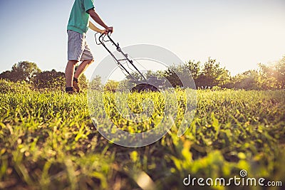 Young man mowing the grass Stock Photo