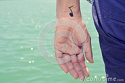 Young man with a musical note painted in his wrist Stock Photo
