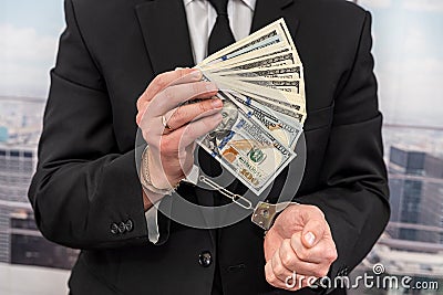 a young man nicely dressed in a dark suit is detained for counterfeit dollar bills. Stock Photo