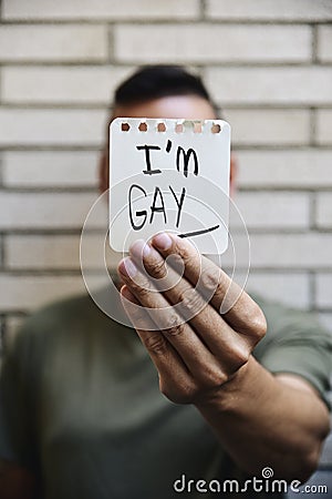 Young man with a note with the text I am gay Stock Photo