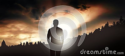 Young man observes the forest on the mountain Stock Photo