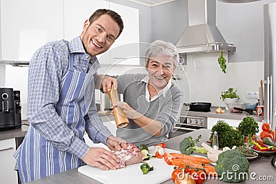 Young man and older woman cooking together in the kitchen. Stock Photo