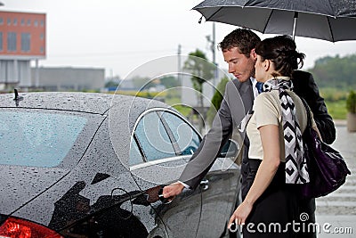Young man opening door of car for woman Stock Photo