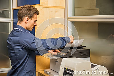 Young Man Operating Photocopier Machine Stock Photo