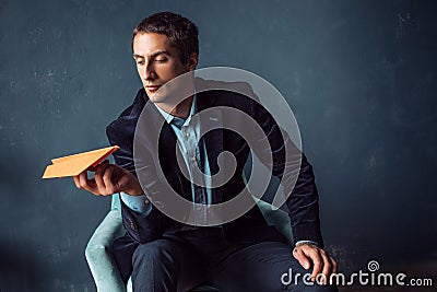 Young man and orange paper planes. Dreams of traveling and flying Stock Photo