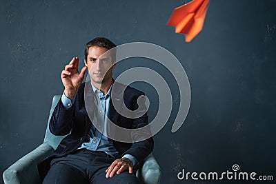 Young man and orange paper planes. Dreams of traveling and flying Stock Photo