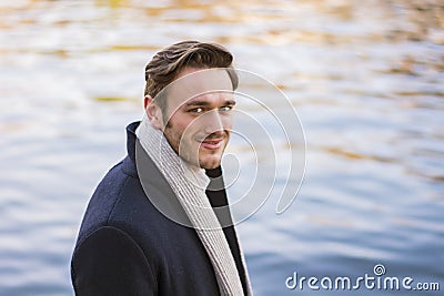 Young man outdoor in winter by lake or river Stock Photo