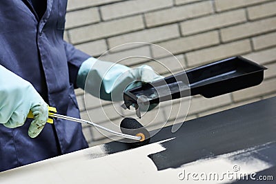 Young man painting a wooden board Stock Photo