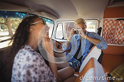 Young man photographing woman from camera Stock Photo