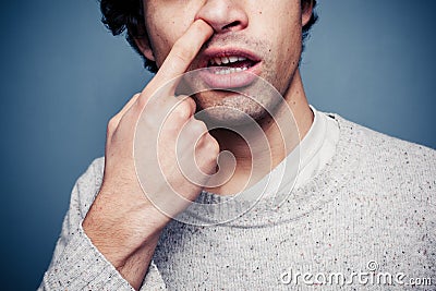 Young man is picking his nose Stock Photo