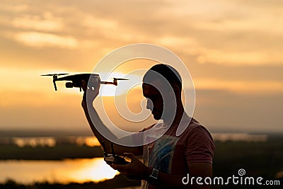 Young man piloting a drone in the evening Stock Photo