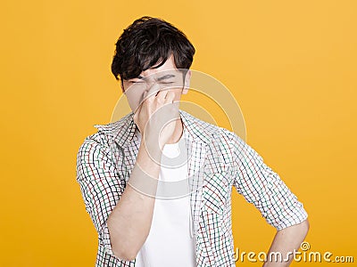 Young man pinches nose with fingers . disgust something stinks bad smell Stock Photo