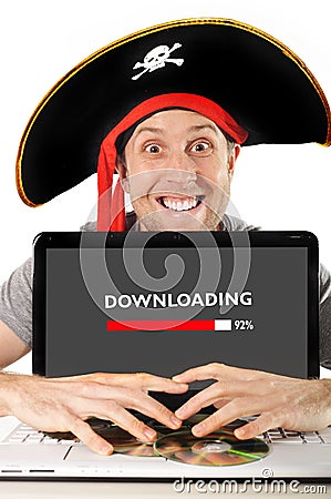 Young man in pirate costume with Computer laptop downloading files copyright violation Stock Photo