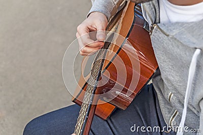 Young man playing guitar on bench in autumn park, look from above Stock Photo