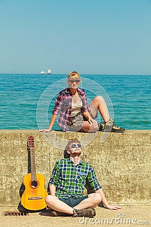 Young man playing guitar to his girlfriend by seaside Stock Photo