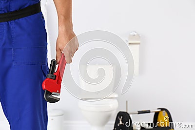 Young man with plumber wrench and toilet bowl Stock Photo