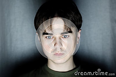 Young man portrait face in dark room at dark background,handsome youngster serious face, programmer coding at night, hacking Stock Photo