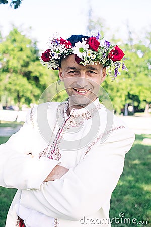 Young man posing in traditional folk costume. Cossack male in a wreath and embroidered shirts. Reconstruction of old traditions Stock Photo