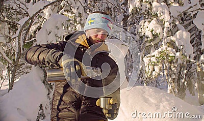 Young man pouring tea from a thermos Stock Photo