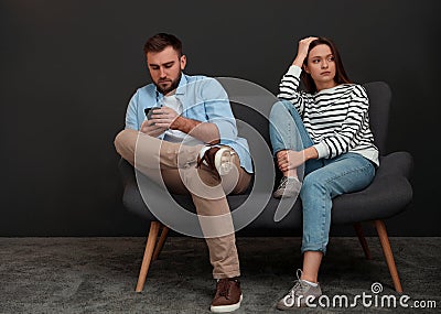 Man preferring smartphone over his girlfriend at home. Relationship problems Stock Photo